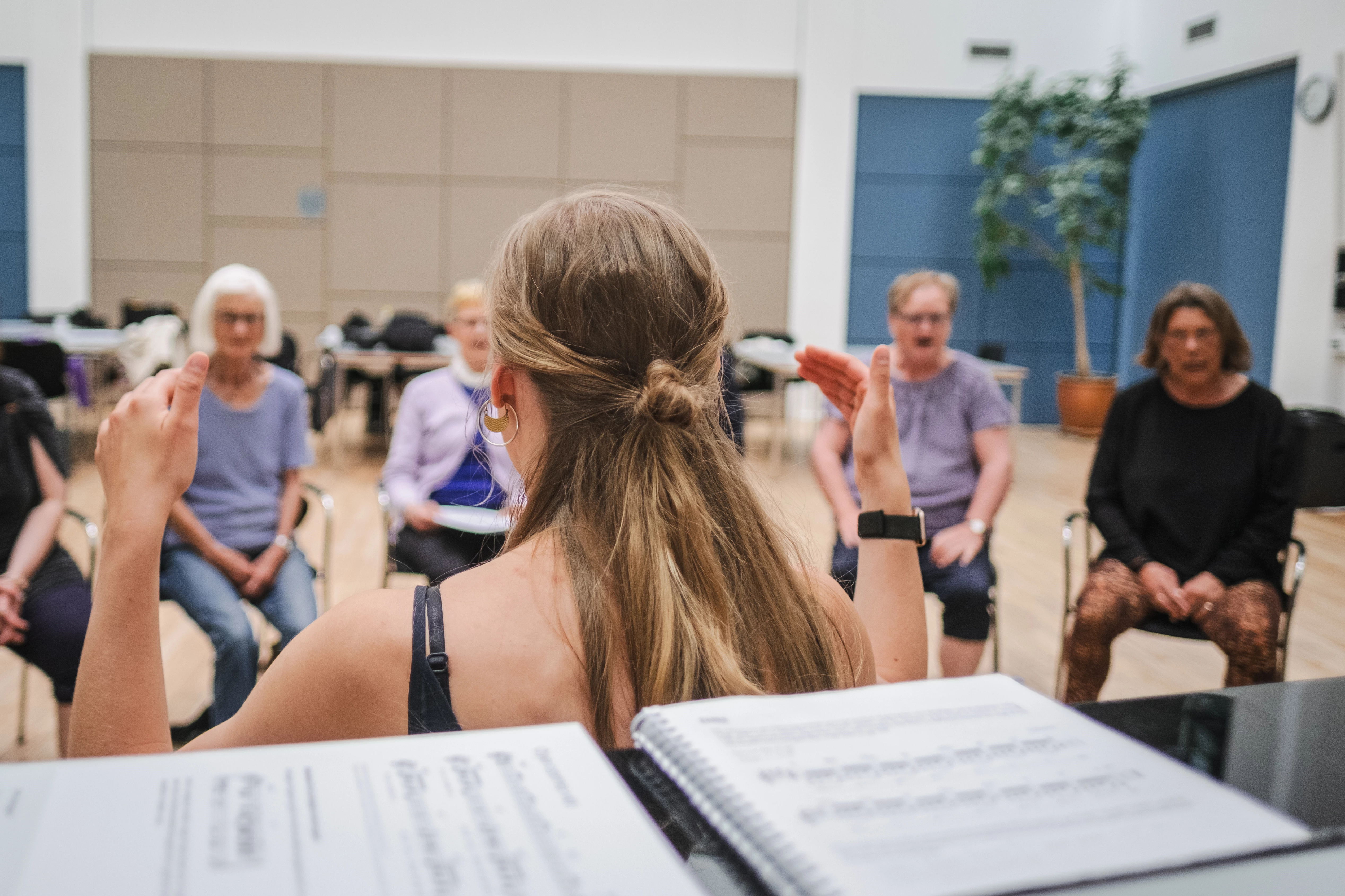 Kvinde dirigerer et kor